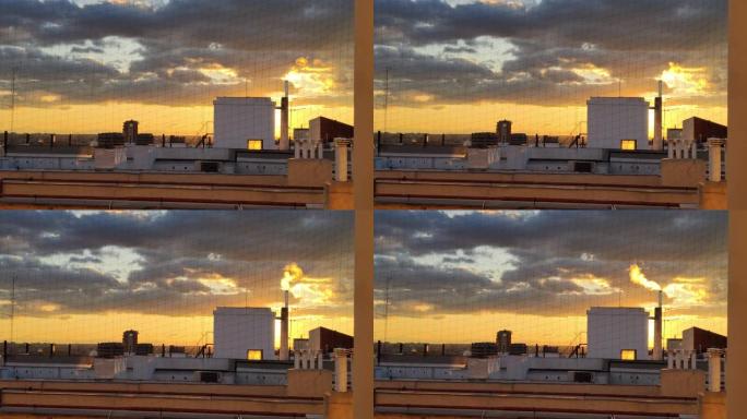 冬天日落时分的马德里屋顶，烟囱冒烟