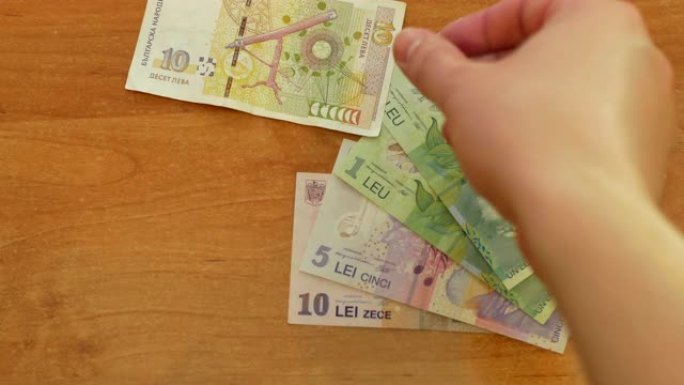 手在桌子上撒上欧元钱