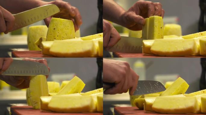 厨房里的厨师用刀切开菠萝。这是一个很棒的餐厅里的奢华烹饪 -- 特写视角 -- 烹饪概念