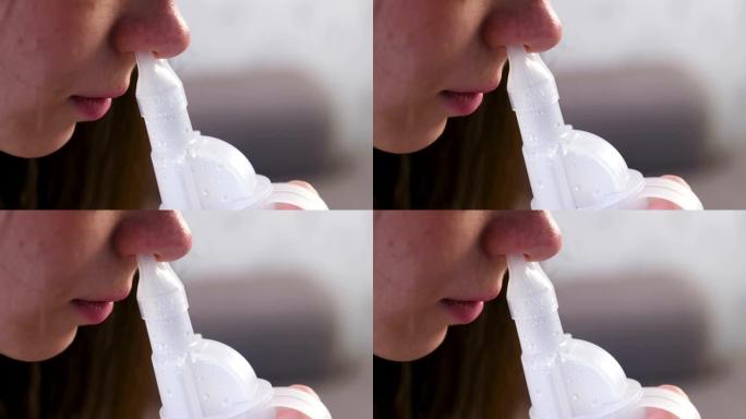 使用雾化器和吸入器进行治疗。年轻女子通过鼻子的吸入器喷嘴吸气。特写鼻子。