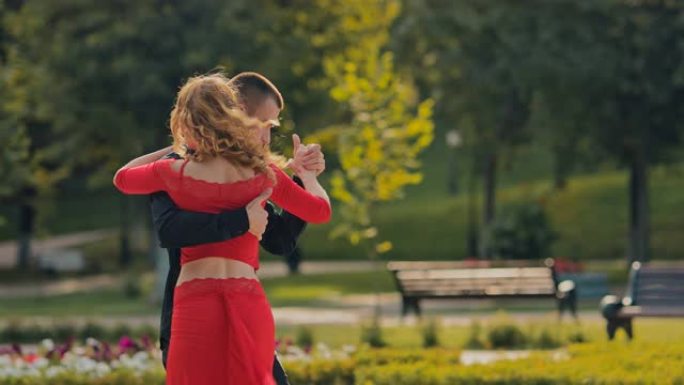 舞蹈中的运动，一个男人和一个女人跳探戈。夏天在城市公园训练。肖像视图。