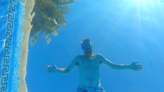 一名戴着潜水镜的男子在镜头前游泳