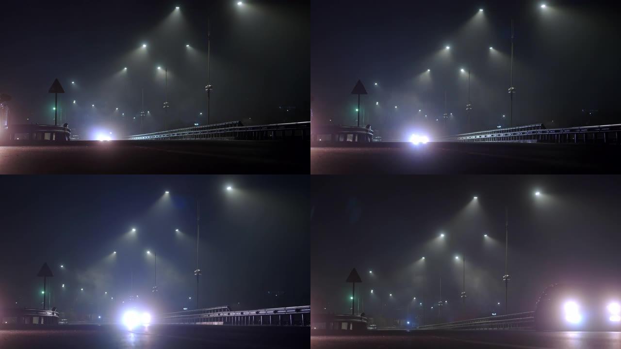 汽车晚上在潮湿的雾气路上行驶。危险的夜间驾驶。高速公路上的灯亮着