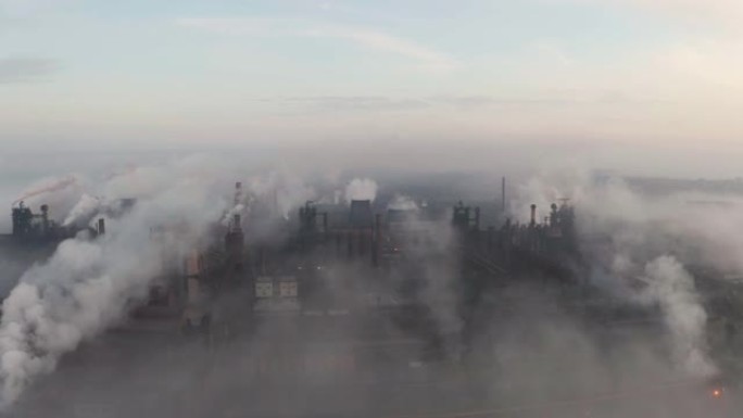 日出时间的钢厂管道。冶金厂上方高处，烟云从烟囱冒出