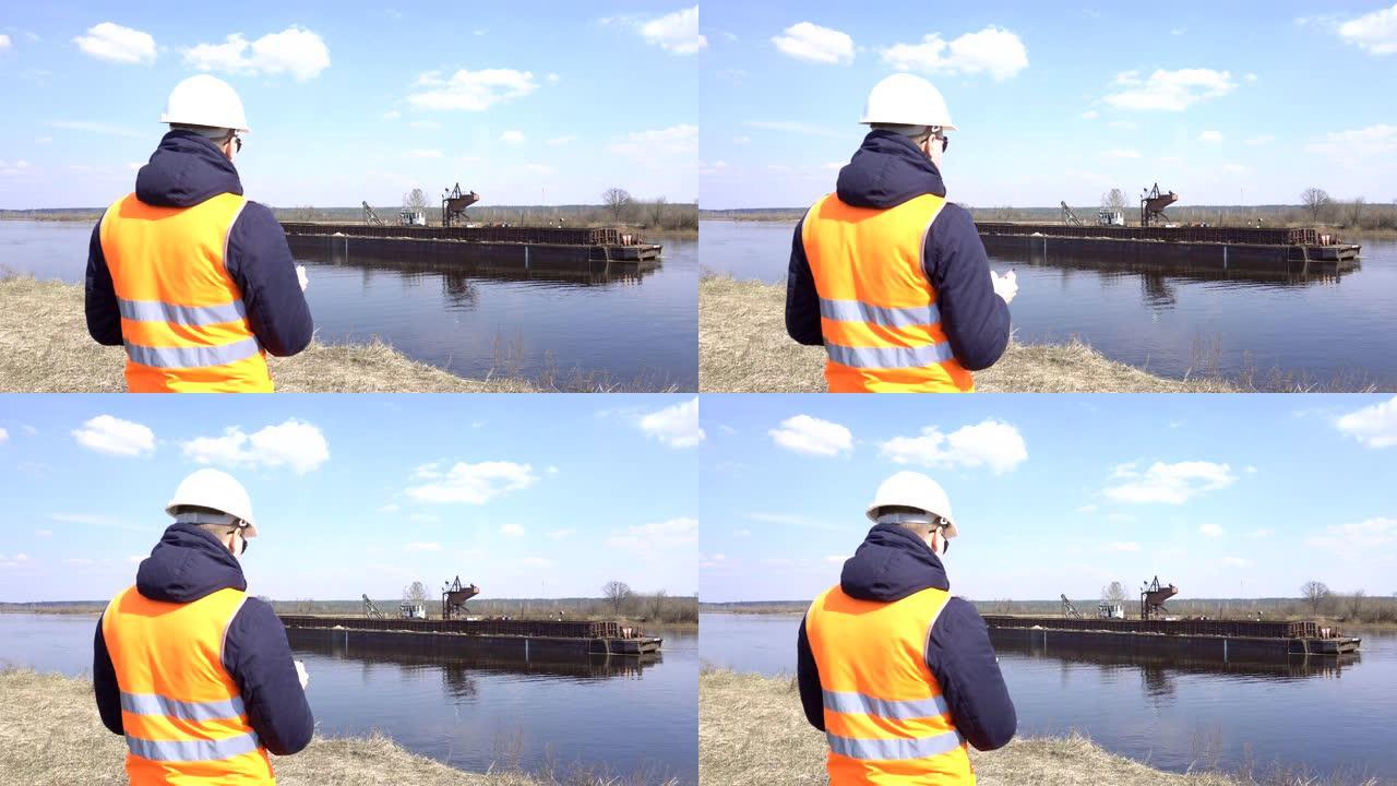 信号背心中的检查员监视建筑，工业用河砂提取的工作质量