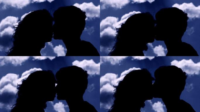 恋爱中的年轻夫妇的剪影，在日落时接吻。浪漫，爱情