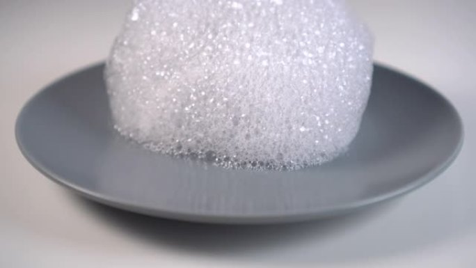 灰色陶瓷板上的洗涤剂泡沫滴