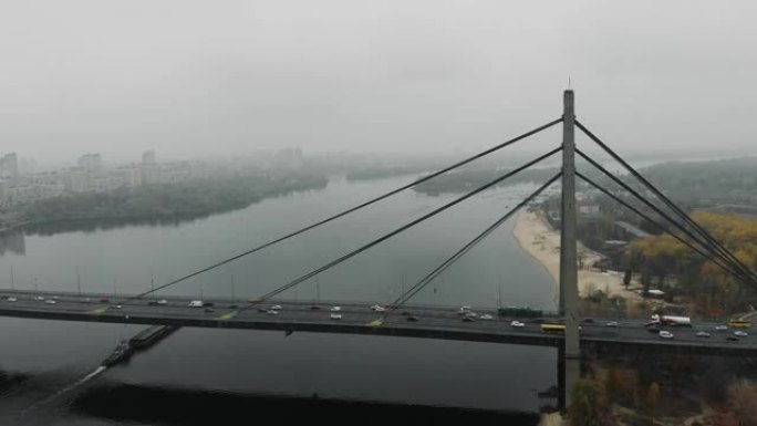 带有汽车交通的混凝土桥结合了大都市的两侧。大灰色桥，在市区的河上有汽车，空中无人机