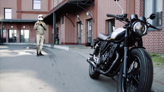 骑自行车的人戴上头盔，留在办公室附近的摩托车后面，慢动作