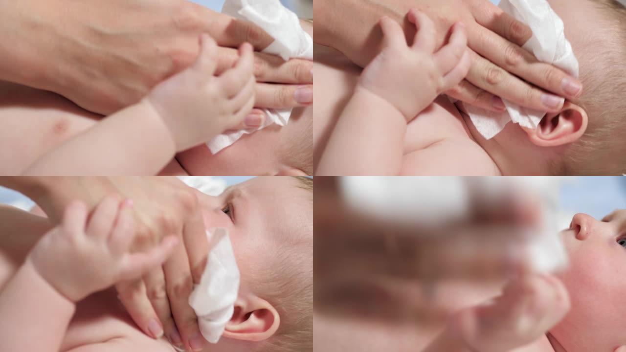 妈妈用湿巾擦拭婴儿的脸。孩子躺在蓝色背景的白色毯子上，母亲用湿布擦脸。慢动作