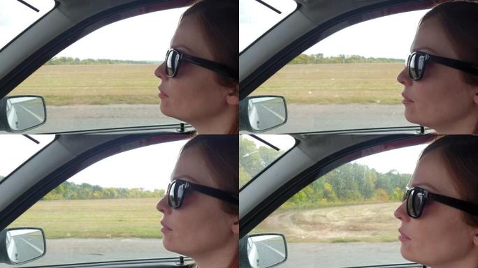女人戴着墨镜坐在车里，开车旅行