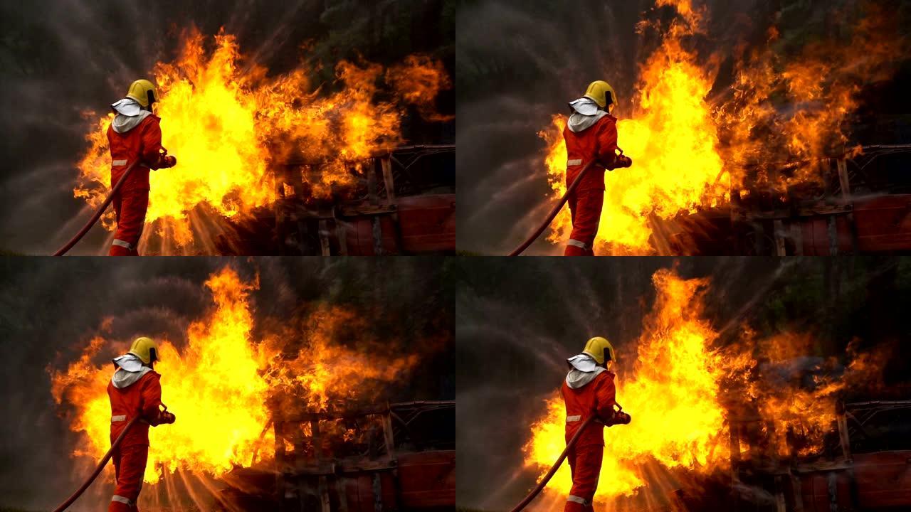 勇敢的消防员的慢动作镜头使用带有螺旋水的消防水带扑灭车祸中的大火