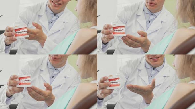 持有牙科模具的男性牙医向患者解释牙齿护理