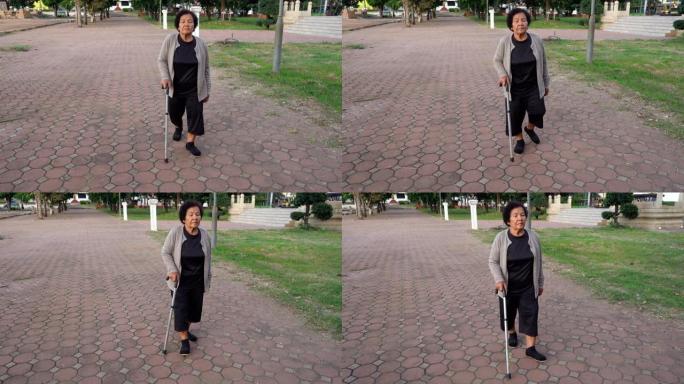 老年妇女在公园里用手杖走路