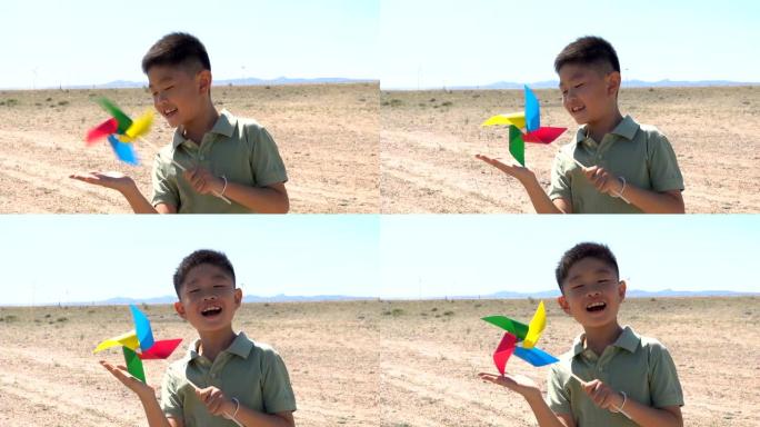 亚洲男孩在风电场玩风车