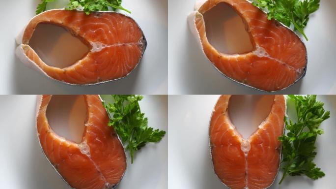 带新鲜鲑鱼鱼牛排的盘子在微波俯视图中旋转