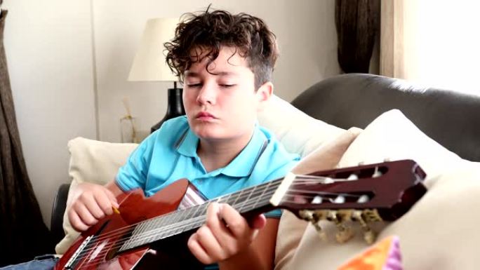 小男孩在家演奏经典吉他