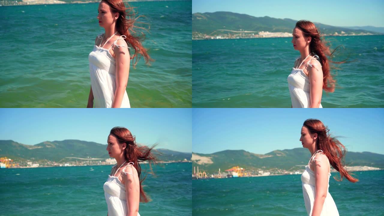 一个穿着白色沙滩装的女孩沿着海边散步。一个光着脚的漂亮女孩沿着海边散步。