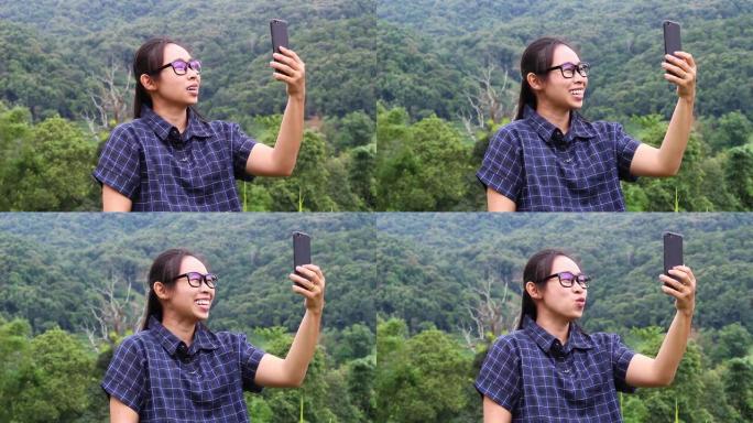 亚洲年轻女子在梯田用智能手机自拍。