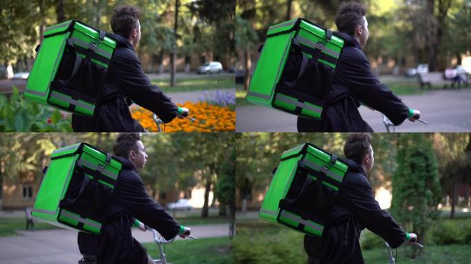 带绿色背包的送货员骑着自行车穿过城市，带食物