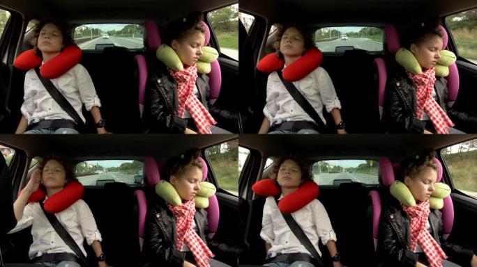坐在后座时，带着旅行枕头的少年男孩和女孩睡在汽车座椅上。兄妹一起旅行