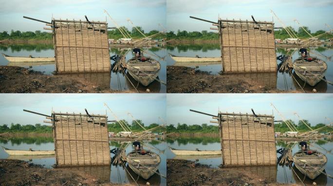 退潮时从河中冒出来的竹鱼箱; 中国渔网后面