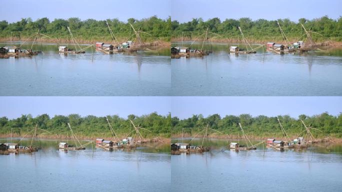 河上的船屋和中国渔网。费舍尔将中国渔网从水中抬起