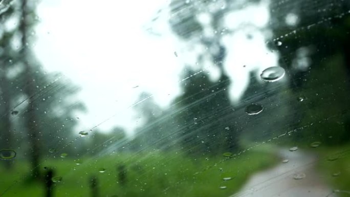 下雨，在下雨的时候在路上行驶，雨滴滴在玻璃窗上