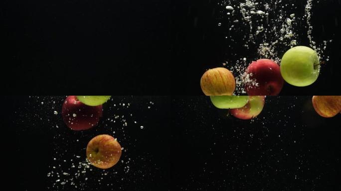 慢动作视频，苹果，在黑色背景上掉入水中