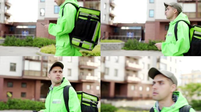 穿着绿色制服的年轻男性食品快递员在手机上使用手机导航应用程序在城市街道上用隔热背包运送食物时倾斜跟踪