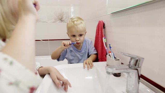 穿着睡衣的兄妹在浴室镜子前刷牙