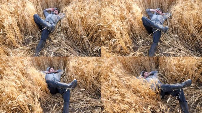 多莉拍摄的年轻农民躺在小麦茎上，在大麦草地上休息。男性农艺师躺在大麦茎上，在谷物田里放松。农业商业概