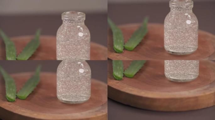 装满芦荟凝胶的玻璃瓶的顶部底部照片。背景模糊的芦荟植物的叶子。敏感肌肤天然有机更新化妆品。选择性聚焦