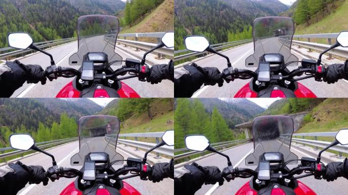 骑摩托车的摩托车手在瑞士阿尔卑斯山附近的一条美丽的风景山路上骑行