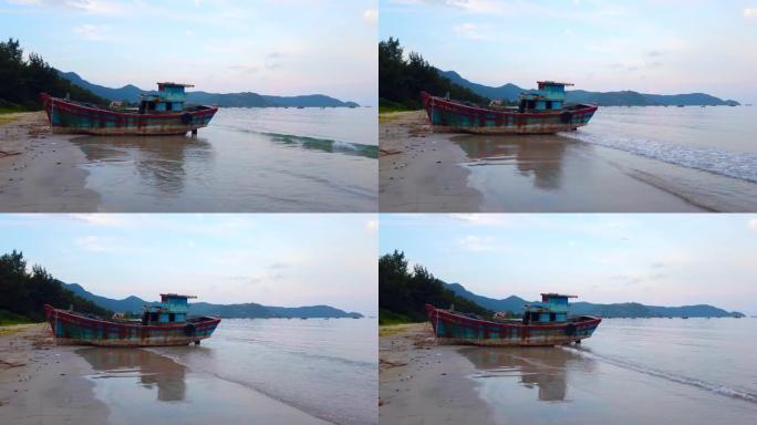 黄昏时分在越南康岛海滩上废弃的木头渔船沉船