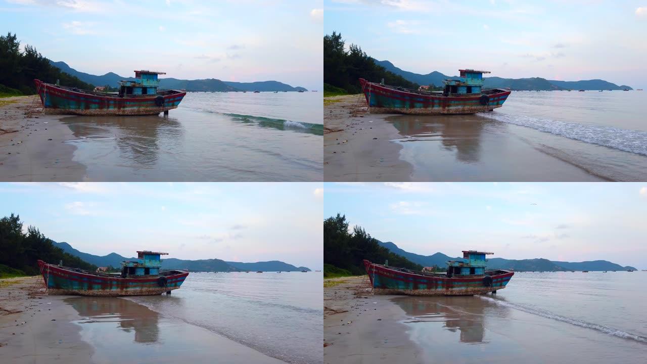 黄昏时分在越南康岛海滩上废弃的木头渔船沉船