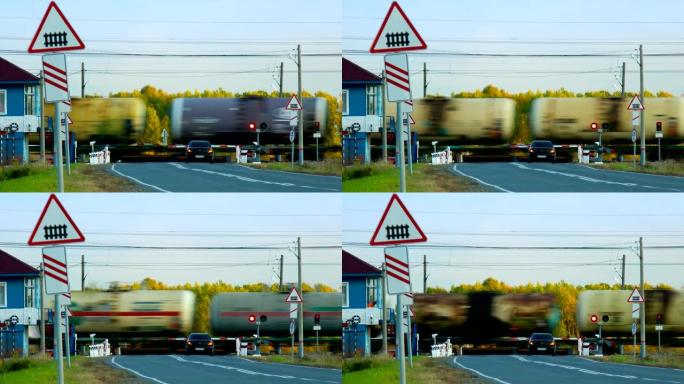 货运罐车在森林处通过铁路道口行驶