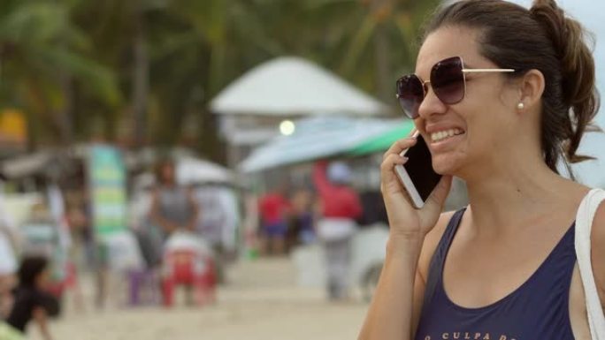 在伯南布哥州的波尔图德加利尼哈斯海滩，女人在手机上聊天