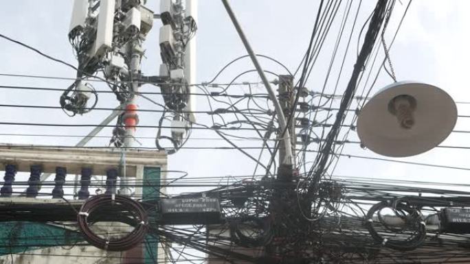 泰国的电线乱七八糟。从泰国晴朗天空背景下的电线混乱。电气通信中的危险混乱。