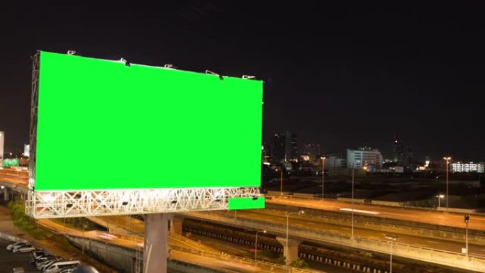 泰国曼谷城市背景下的黄昏期间，高速公路上广告广告牌的延时绿屏。