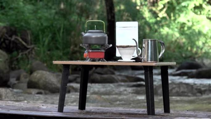 滴咖啡，咖啡师将水倒在咖啡粉上，带过滤器，放在木制桌子上滴咖啡