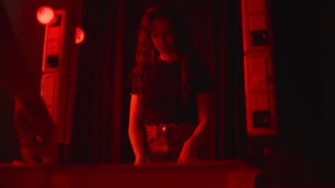 年轻女子在黑暗的房间里显影一张相纸