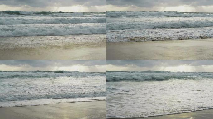 海水的慢动作，大海浪在雨云天空下溅起海滩。