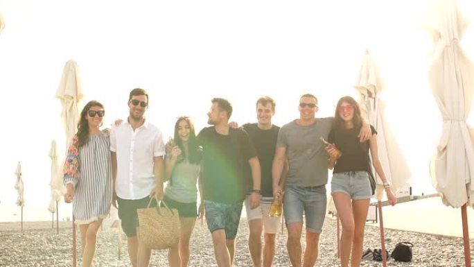 假期，假期。一群朋友在海滩上玩得开心，散步，喝啤酒，微笑和拥抱