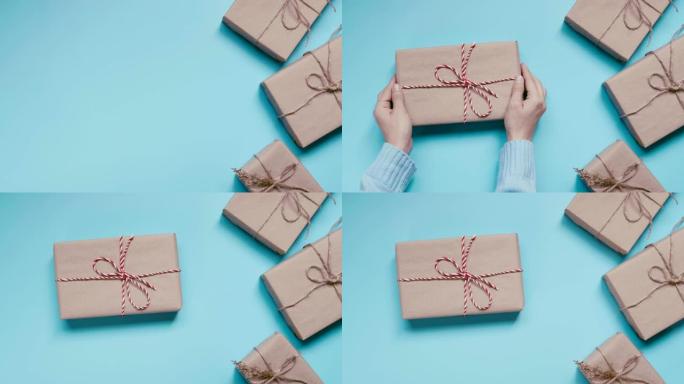 女人双手拿着蓝色背景上的工艺纸礼品盒。现在的圣诞节、新年、情人节或周年纪念日。