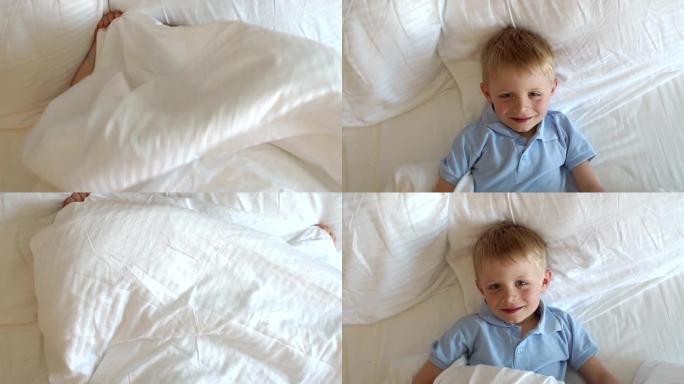 床上的小孩用条纹毯子或床罩遮住脸的俯视图