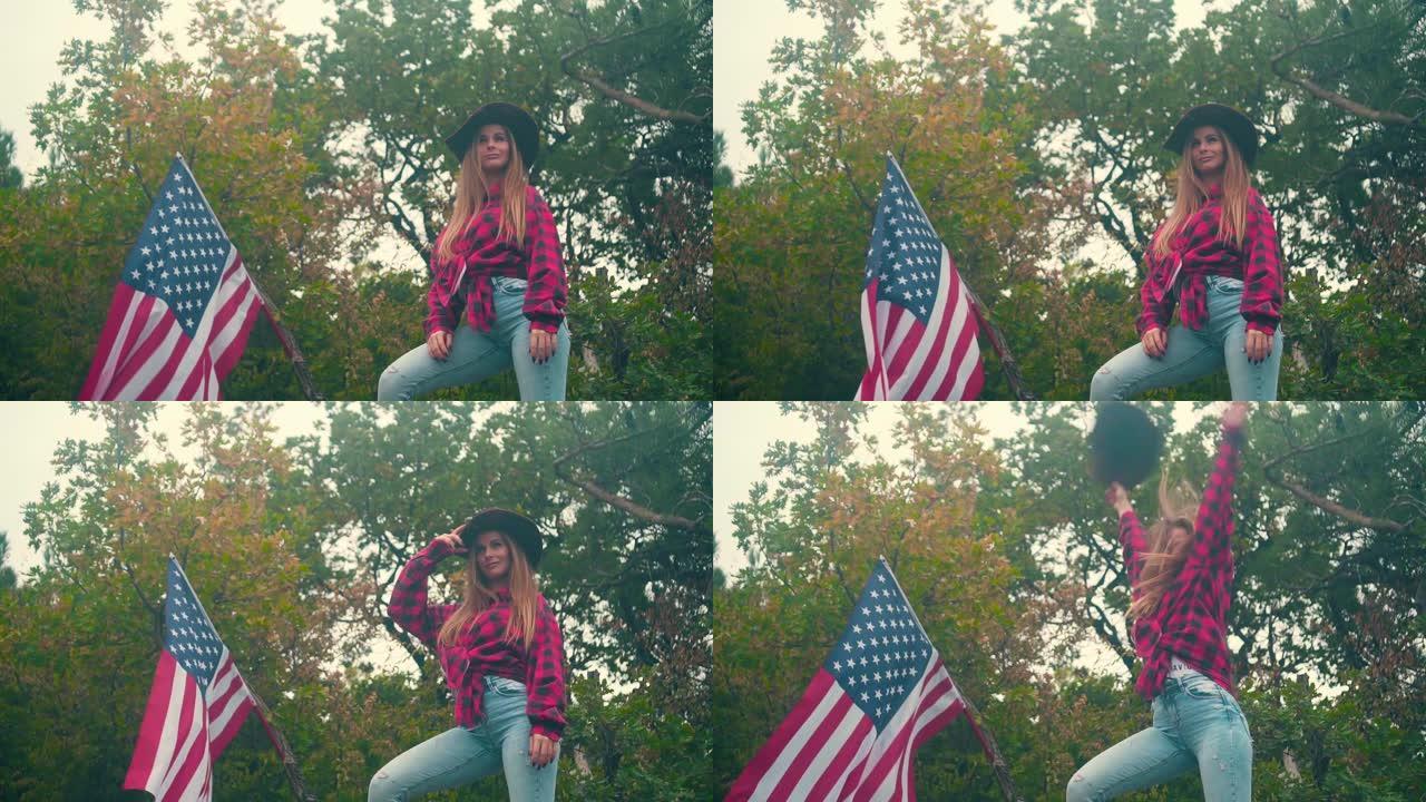 一个戴牛仔帽、穿格子衬衫的女孩站着。背景是一面美国国旗在风中飘扬。