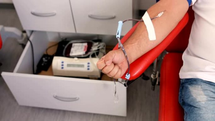 善行。为身体献血的好处。接受输血的接受者的手。在医疗诊所献血的献血者的特写