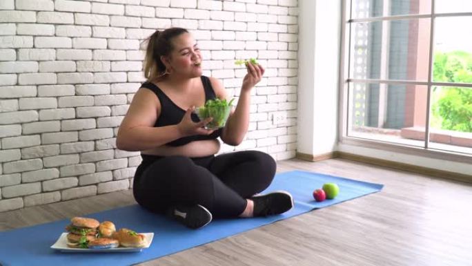 侧视图: 泰国超重妇女吃健康食品作为蔬菜沙拉而忽略不健康食品作为甜面包