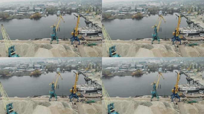 从铁驳船中提取河砂的码头工业城市和货物作业起重机的鸟瞰图